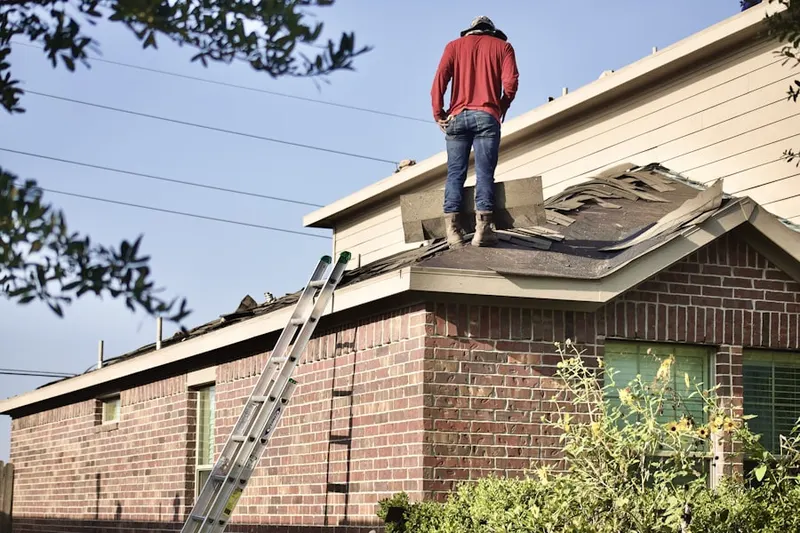 Professional roofer working on a residential roof in Livingston